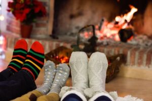 Feet in Christmas socks by an open fire