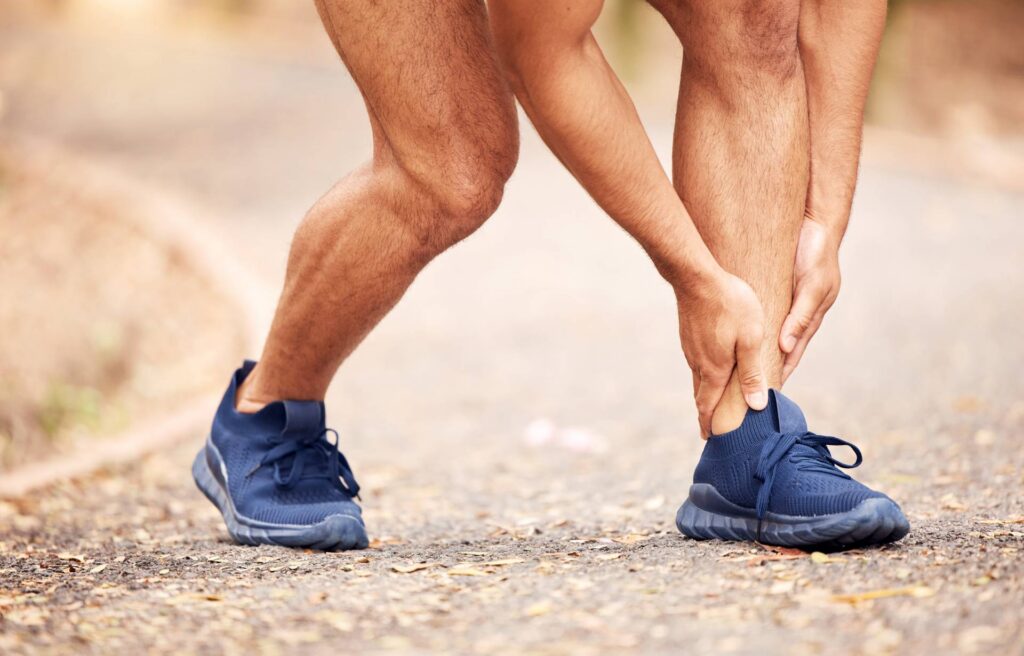 Shot of an unrecognisable man experiencing ankle pain while working out in nature
