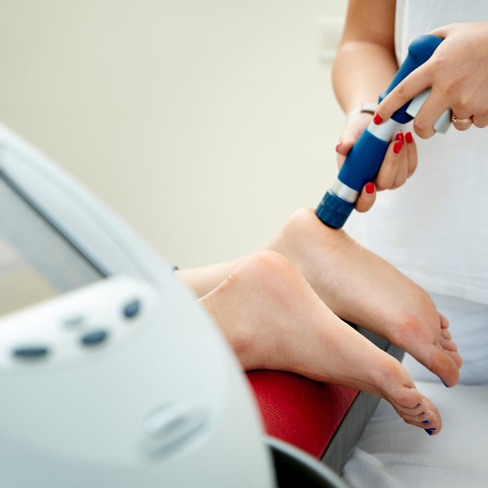 Doctor neurologist using shockwave to relieve pain heel spur. Close up view. Extracorporeal Shockwave Therapy. Effective non-surgical treatment to speed up healing and relieve pain